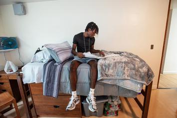 On the first day of orientation, Armand Paul pauses on his bed to review Messina materials.